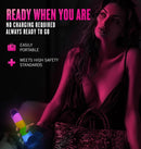 Woman holding Neo Elite Glow in the Dark Rainbow Rave Dildo in dark setting, highlighting portability and safety.