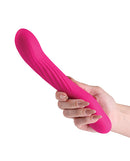 INYA Wiggle Stick Gyrating Vibrator Pink held in hand, showcasing its ribbed design for enhanced pleasure.