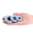 Renegade Players Silicone Cock Ring Gray displayed in hand, showcasing three sizes for enhanced performance.