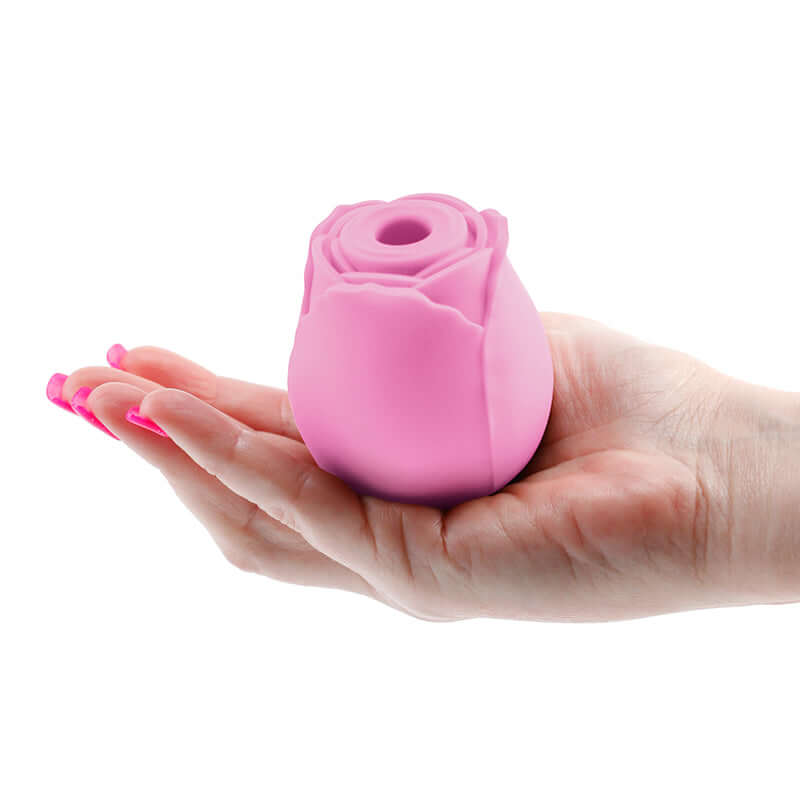 Inya The Rose Rechargeable Suction Clitoral Stimulator Pink held in a hand, showcasing its elegant rose design.