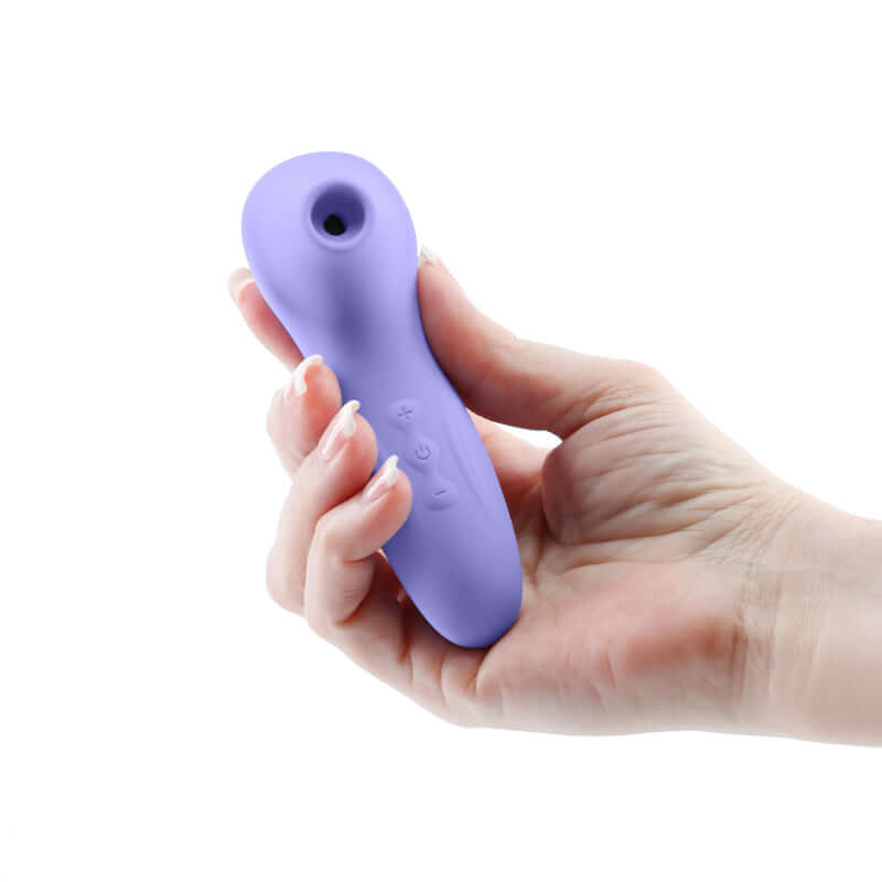 Hand holding the Revel Vera Rechargeable Silicone Clitoral Stimulator in purple, featuring air pulse technology.