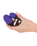 GoGasm Vibrating Pussy & Ass Balls Purple held in hand, showcasing the sleek design and flexible silicone bar.