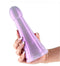 Person holding a flexible and shiny purple Fantasia Phoenix Dildo, designed for luxurious and stimulating experiences.