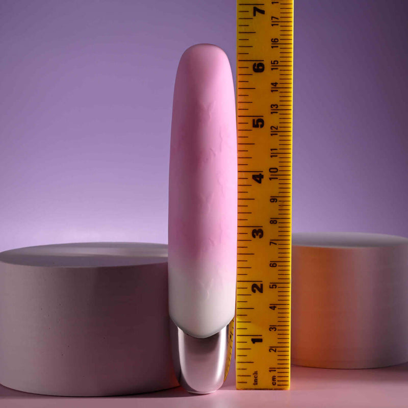 Playboy Bunnies on Parade pink silicone vibrator next to a ruler for size comparison.