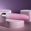 Playboy Bunnies on Parade rechargeable silicone vibrator in pink on white pedestals, highlighting its sleek design.