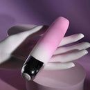 Pink rechargeable silicone vibrator with clitoral stimulator resting on a hand against a purple background.