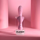 Playboy Rabbit Party Silicone Rabbit Vibrator Purple displayed on stand against a pink backdrop.