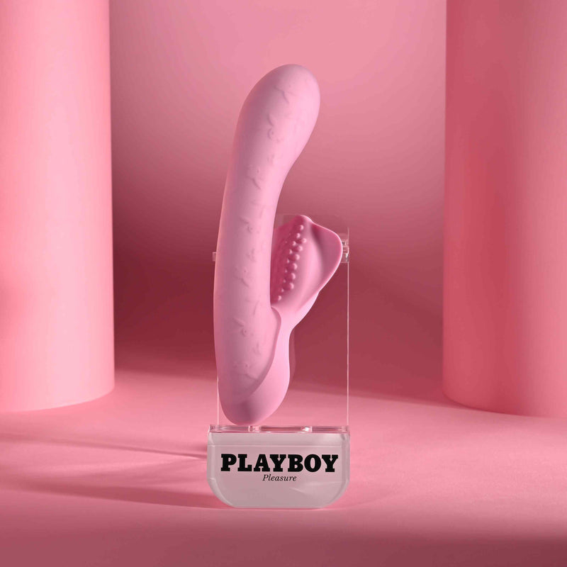 Playboy Rabbit Party Silicone Rabbit Vibrator Purple displayed on a pink background.