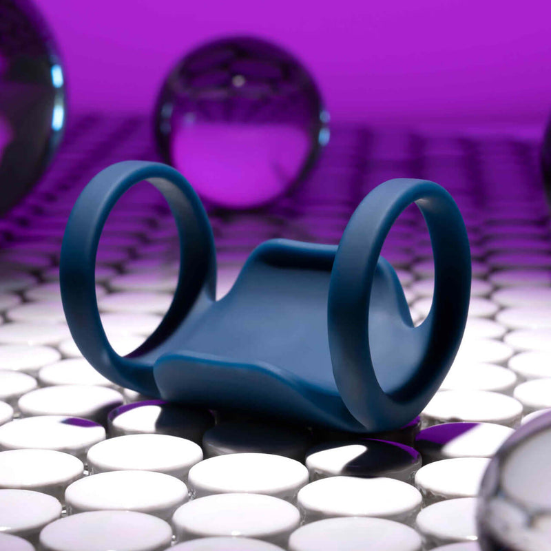 Playboy Jet Pack Double-Ring Penis Vibrator in blue silicone for enhanced pleasure against a modern backdrop.
