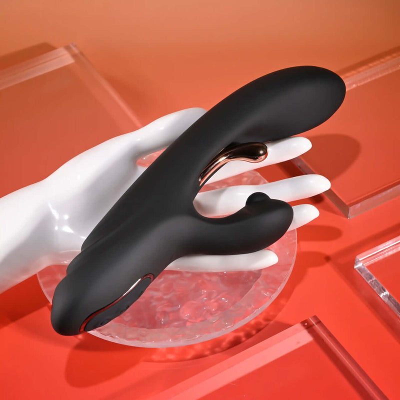 Playboy Aureus rechargeable silicone vibrator with remote, designed for G-Spot stimulation, shown on a hand.