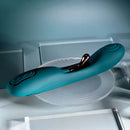 Playboy Aurelie rechargeable silicone G-Spot vibrator in green with rose gold accents on a glass surface.