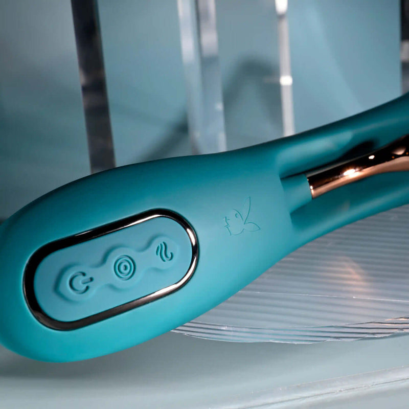 Close-up of Playboy Aurelie rechargeable silicone G-Spot vibrator, featuring control buttons and sleek rose gold accents.