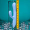 Playboy Up and Away blue silicone rabbit vibrator next to a measuring tape, showcasing its unique design.