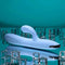 Playboy Up and Away rechargeable silicone rabbit vibrator in blue displayed on a reflective surface with ice cubes.