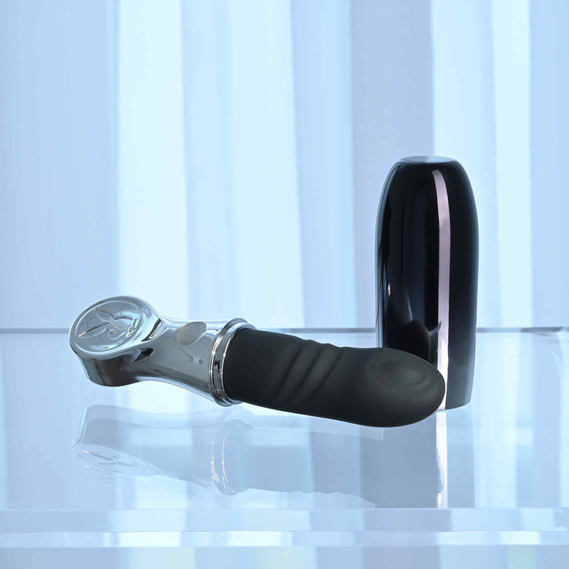 Playboy Bon Voyage Rechargeable Silicone Vibrator on a reflective surface with a sleek black case.