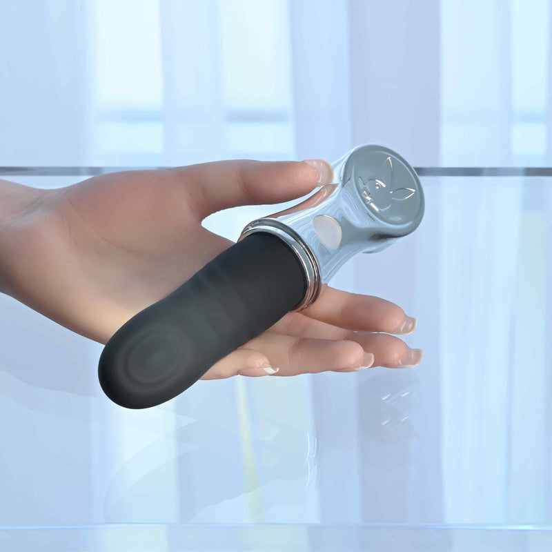 Playboy Bon Voyage Rechargeable Silicone Vibrator held in a hand on a reflective surface.