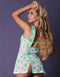Woman wearing Reefer RN Cannabis Nurse Costume in neon green pot leaf print, side view showing mini dress in white sheer stretch mesh.