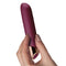 Chaiamo Burgundy rechargeable silicone vibrator held in hand, showcasing its elegant design and powerful features.