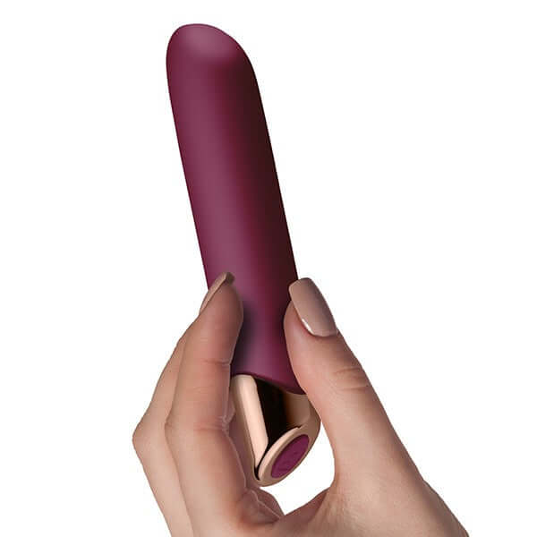 Chaiamo Burgundy rechargeable silicone vibrator held in hand, showcasing its elegant design and powerful features.