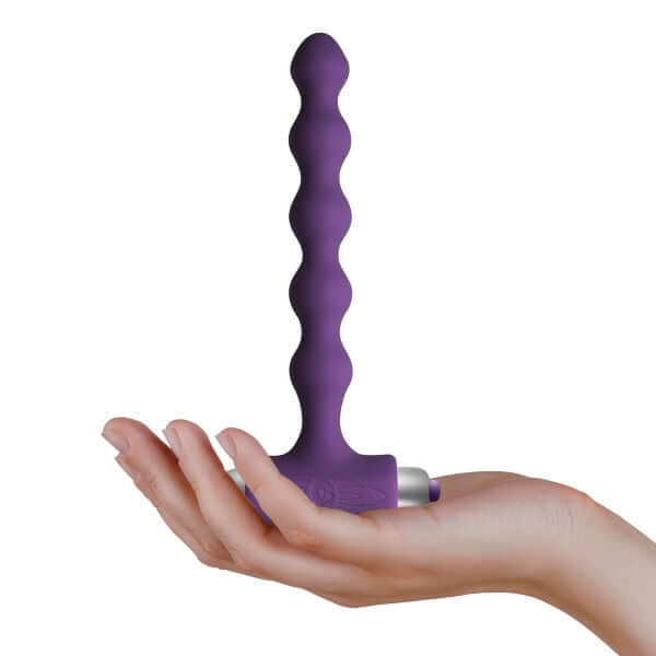 Petite Sensations Pearls Purple vibrating anal beads held in hand, showcasing its sleek silicone design and powerful functions.