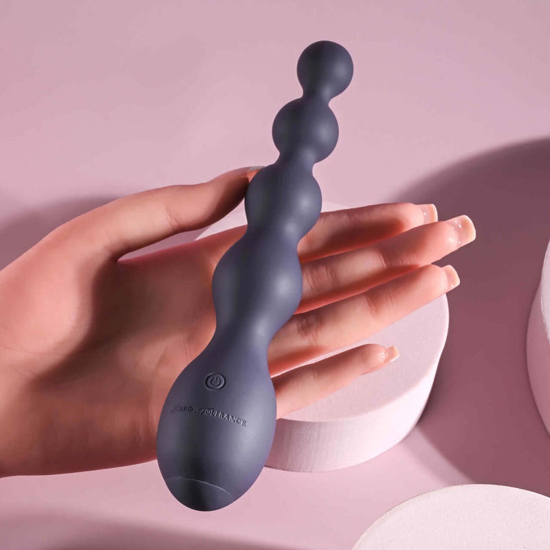 Hand holding Zero Tolerance Rumpy Bumpy beaded vibrator with 10 speeds and waterproof design for maximum pleasure.