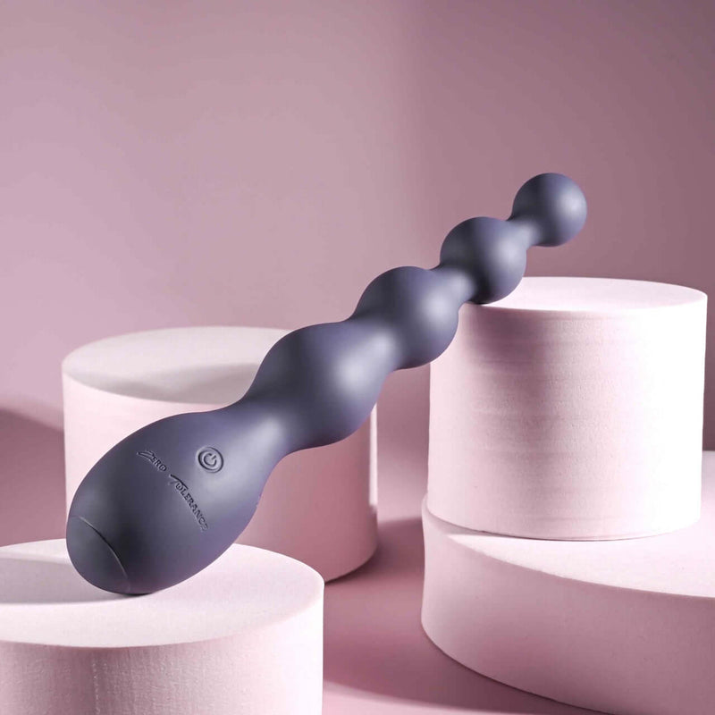 Zero Tolerance Rumpy Bumpy beaded vibrator with 10 speeds and waterproof design, gray, placed on white cylindrical platforms.