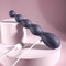 Zero Tolerance Rumpy Bumpy beaded vibrator with charging cable, featuring a flexible shaft and graduated bulbs, on a pink background