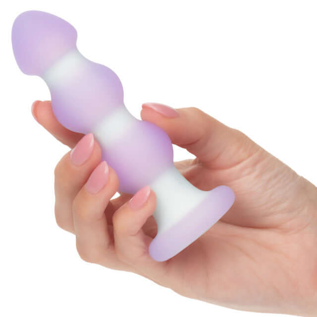 Hand holding Lavender Haze Beaded Probe Vibrating Anal Stimulator with smooth beaded structure and dual-layer silicone.