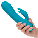 Hand holding Thicc™ Chubby Thrusting Tickler, a teal adult massager with a turbo-charged triple motor system and ribbed shaft.