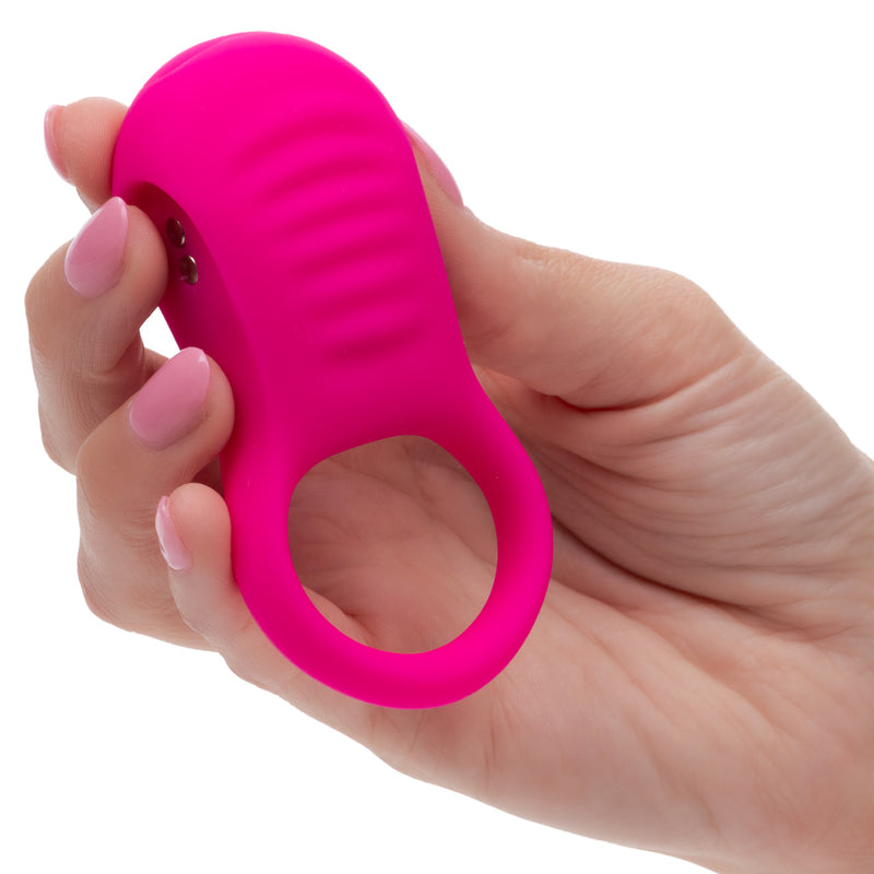 Basic Essentials Vibrating Ridge Rider Silicone Cock Ring Pink held in a hand showing its sleek design.