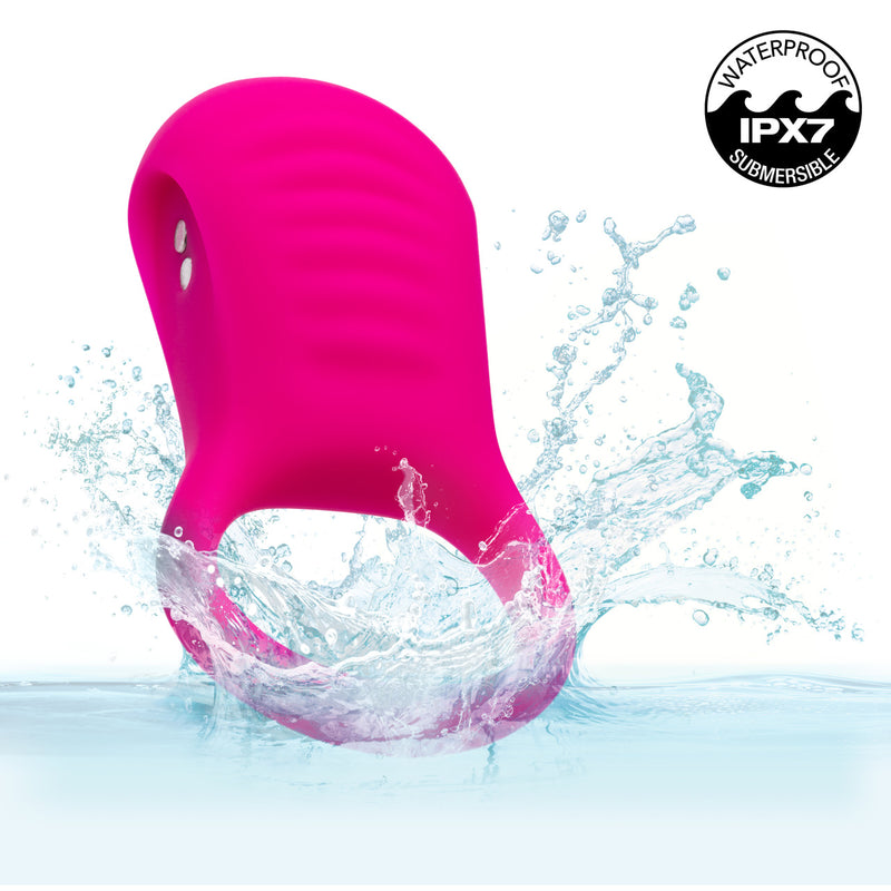 Basic Essentials Vibrating Ridge Rider Silicone Cock Ring Pink splashing in water, showcasing its waterproof design.