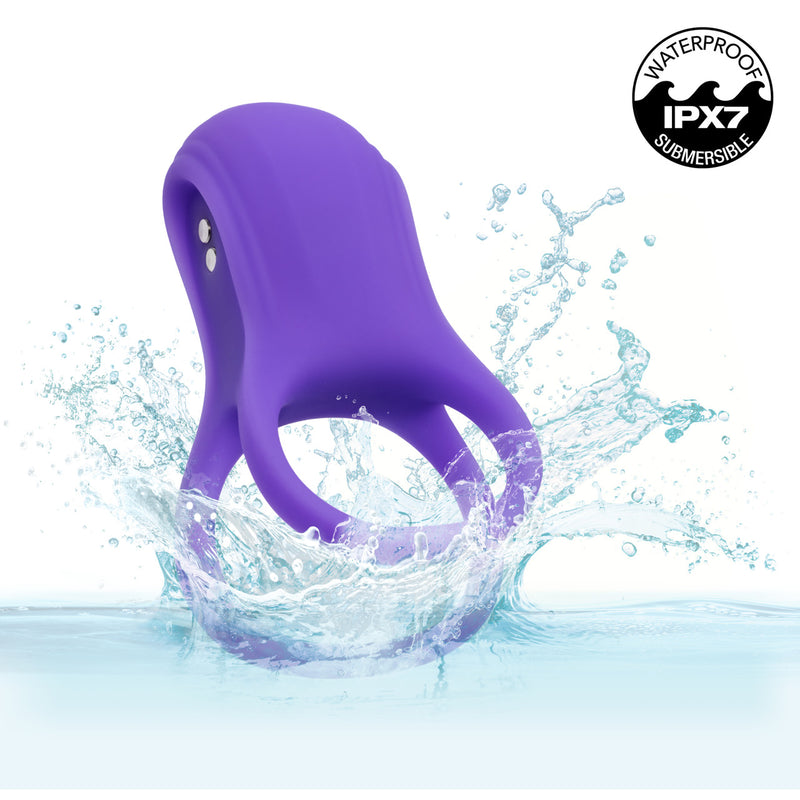 Basic Essentials Vibrating Dual Support Cock Ring Purple submerged in water, showcasing its waterproof IPX7 feature.
