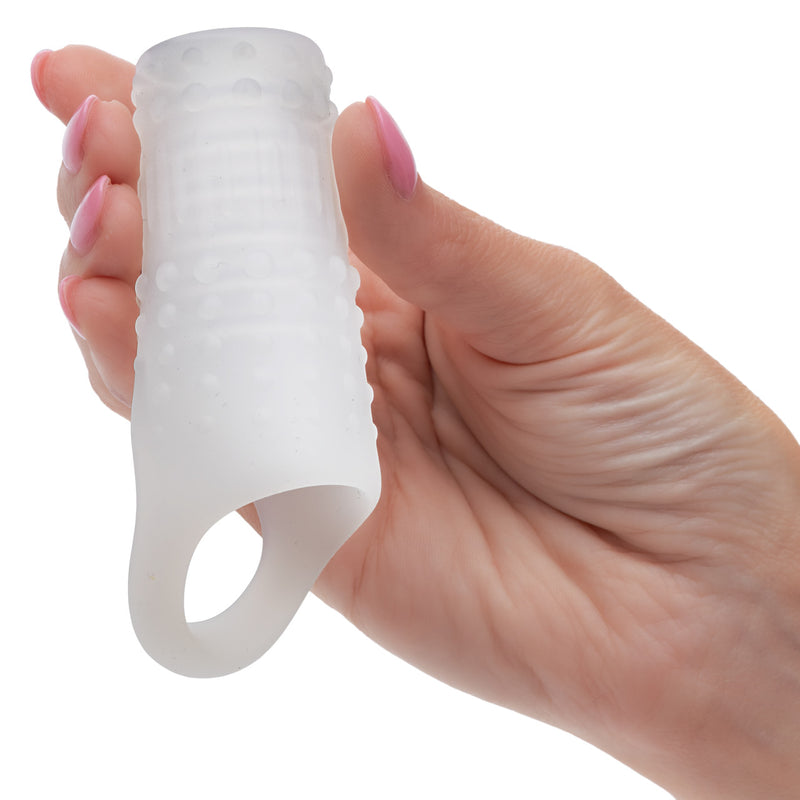 Basic Essentials Liquid Silicone Pleasure Enhancer Clear held in hand, showcasing its flexible design for enhanced comfort.