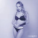 Woman in lingerie holding Nocturnal Collection Heart Throb Paddle, showcasing playful and seductive BDSM elements.