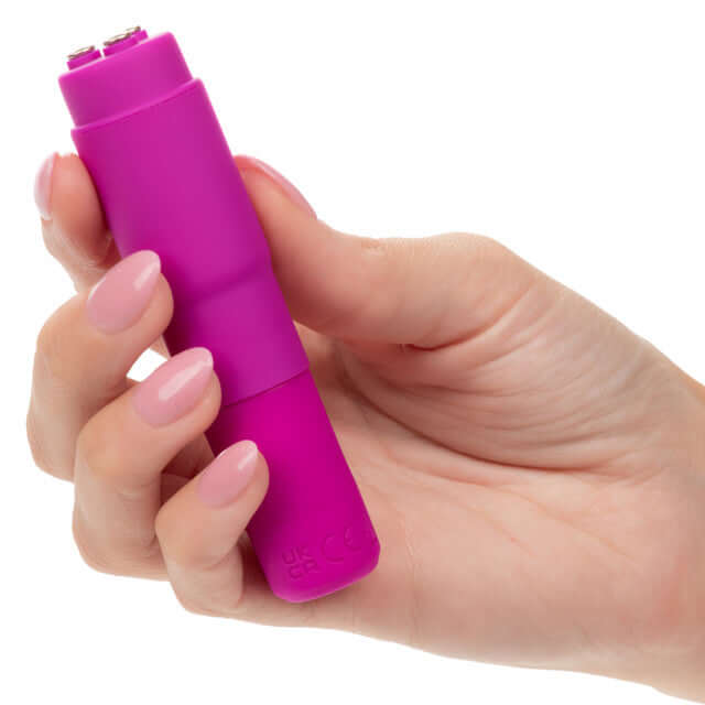 Hand holding Kyst Mega-Mite Pink 10 Function Rechargeable Mini Wand Vibrator with compact design for versatile pleasure.