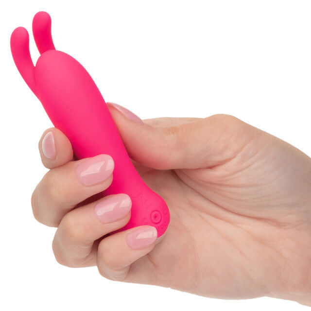 Person holding Kyst Bunny 10 Function Rechargeable Bullet Vibrator with bunny ears in vibrant pink color.