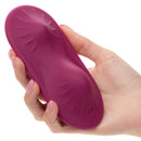 Hand holding the Dual Rider Remote Control Grinder massager with textured surface and vibrant pink color.