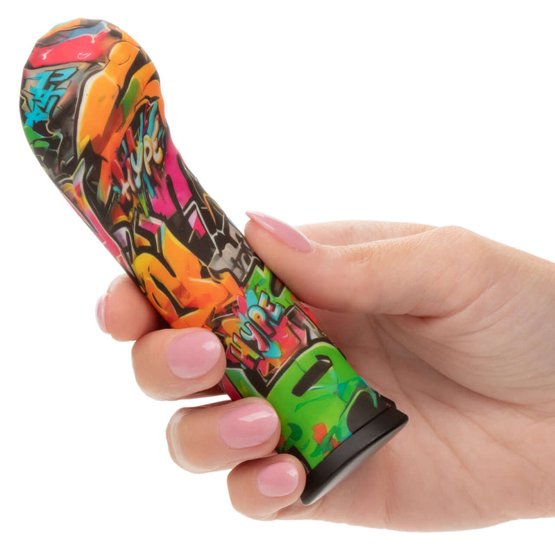 Person holding Hype Mini G petite vibrator with graffiti design for intense G-spot pleasure and 10 turbo-charged speeds
