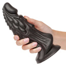 Liquid silicone fantasy dildo with monstrous design and suction cup base held in hand