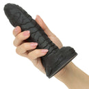Monster Dong The Gill Man Silicone Dildo 7.25 inch Black held in a hand showcasing its textured design and sturdy base.