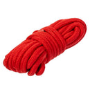 Red rope coiled and ready for use, perfect for Shibari techniques and creative bondage.