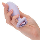 First Time Crystal Booty Duo silicone anal plug in hand, featuring heart crystal inlay, purple color, perfect for backdoor play.