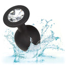 Silicone Gem Anal Kit Black showcasing a black plug with a crystal gem base, splashing water background.