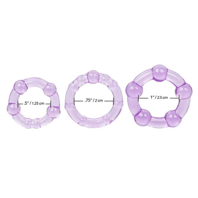 Trio of purple stretchy cock rings in different sizes by California Exotic Novelties, enhancing stamina and pleasure.