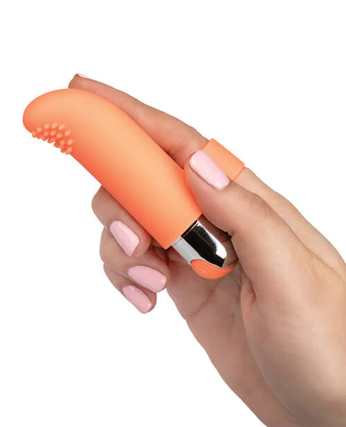 Hand holding Intimate Play Rechargeable Finger Tickler Vibrator in vibrant orange color, designed for pleasure.