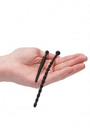 Silicone Beginners Plug Set Urethral Sounding Black displayed in a hand with two distinct plug shapes.