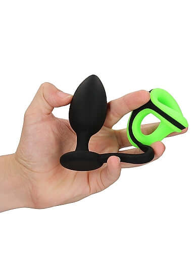Ouch! Glow Butt Plug with Cock Ring and Ball Strap in hand, featuring glow in the dark design, perfect for bondage enthusiasts.