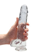 Realrock Crystal Clear Dildo with Balls 9 inches held in hand, showcasing lifelike design and crystal-clear material.