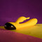 Selopa Buzzz Bunny Rechargeable Silicone Rabbit Vibrator in yellow with black accents on colorful background.
