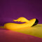Selopa Buzzz Bunny rechargeable silicone rabbit vibrator in yellow on colorful background.